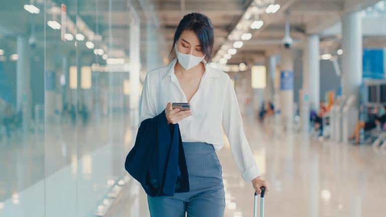 Asian business girl use smart phone for check in boarding pass w
