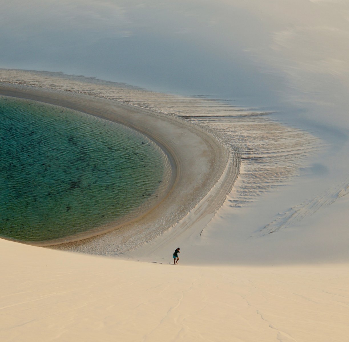旅客走在巴西 Lençóis Maranhenses 白色沙丘與潟湖旁